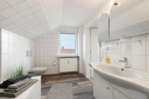 a white bathroom with a sink and a toilet at Ferienwohungen Otto und Grete in Hemmoor