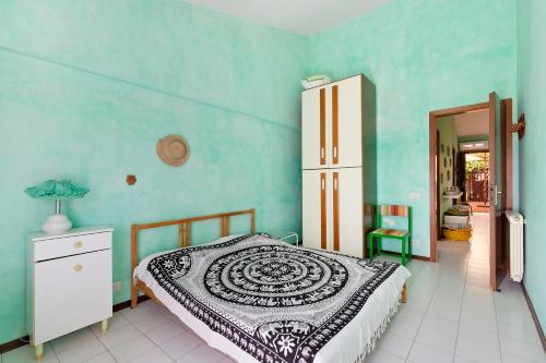 a bedroom with a bed and a blue wall at Casa Vacanze Bouganvillea in Sabaudia