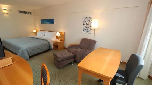 a hotel room with a bed and a chair and a table at 1601 - Hotel & Residence Sol Alphaville Flat in Barueri
