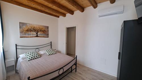 a bedroom with a bed and a painting on the wall at Monte Ricco Appartamenti in Monselice