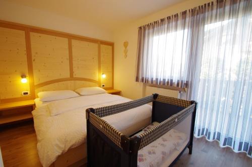 a bedroom with a bed and a large window at Villa Hubertus in Ortisei