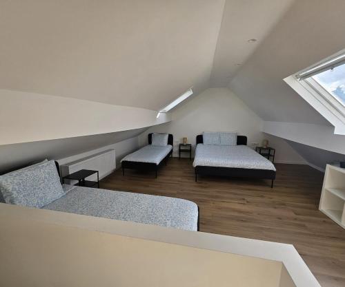 a attic room with two beds and a window at Atomium Apartment 2 in Brussels