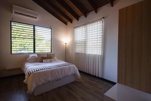 a bedroom with a bed and two large windows at 623 Boquerón Villas in Boqueron