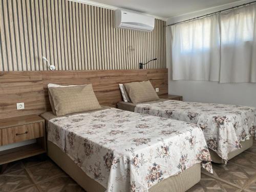 a bedroom with two beds and a window at Paddys Apartments Ovacık in Oludeniz