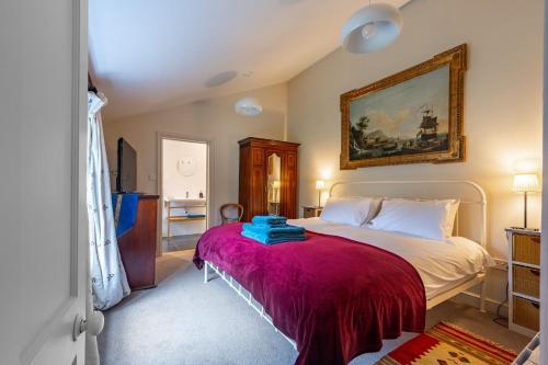 a bedroom with a bed with a purple blanket at The Pottage in Hoxne