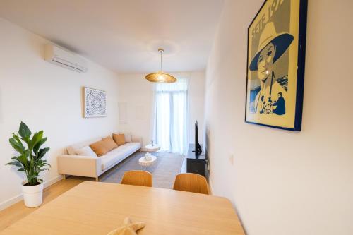 a living room with a table and a couch at Les Suites du Parc - Elégance et lumière face au Parc Simone Veil appartement 2 chambres à 2 minutes des halles in Sète