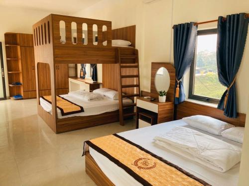 a bedroom with two bunk beds and a window at Trâm Anh Hotel in Kon Von Kla