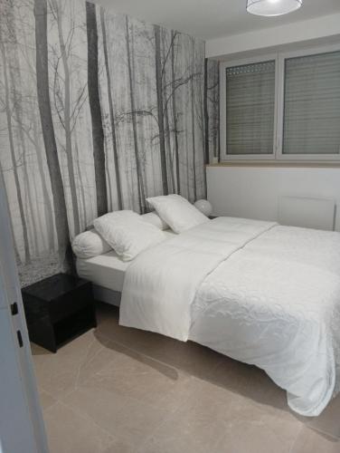 a bedroom with a bed with trees on the wall at Le logis de la liane in Boulogne-sur-Mer