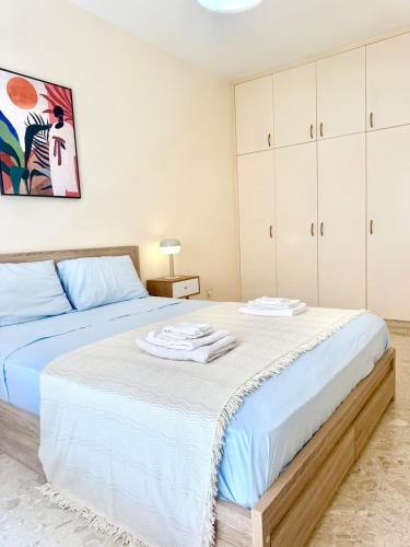 a bedroom with a large bed with white cabinets at Latchi Marina in Lachi