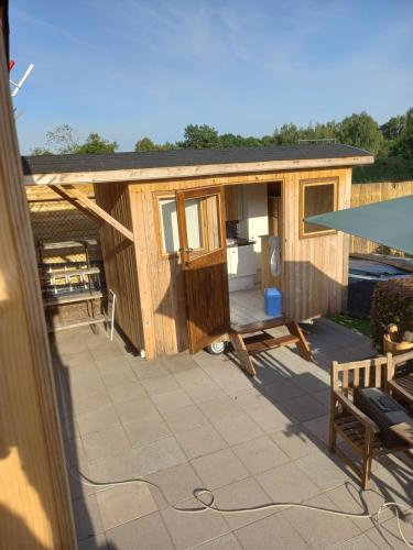 a large wooden cabin with a patio with a table at Casa Otium in Genk