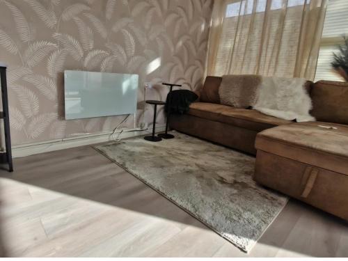 a living room with a couch and a flat screen tv at Home on the Broads Just Renovated in Lowestoft