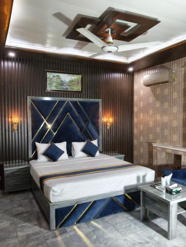 a bedroom with a large bed and a ceiling fan at Star Hotel Lahore in Lahore