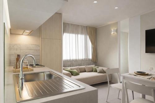 a kitchen with a sink and a living room at Delta Open Air Resort in Porto Garibaldi
