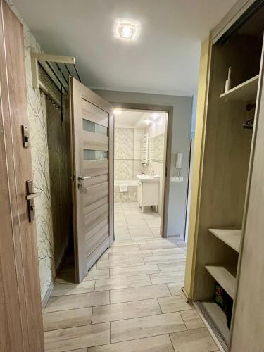 a hallway with a bathroom with a toilet and a sink at Apartament COMFORT Centrum in Krotoszyn