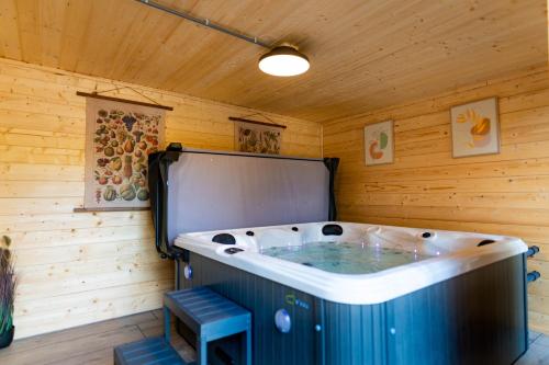 a jacuzzi tub in a room with wooden walls at Luxe wellnesshuis op de Veluwe in Lunteren