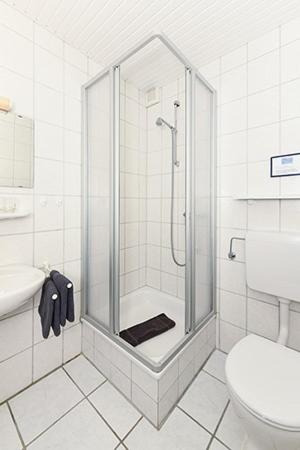 a bathroom with a shower and a toilet at Pension Sielmöwe in Neuharlingersiel