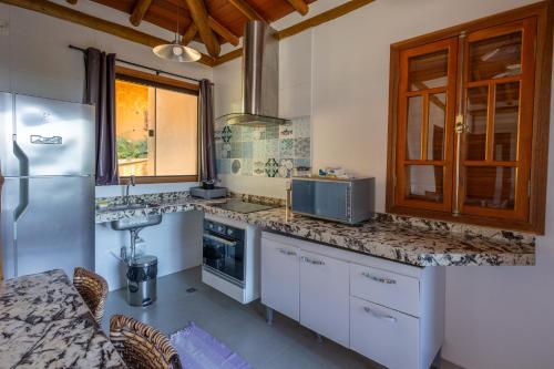 a kitchen with a refrigerator and a counter top at Siriúba Reserve in Ilhabela