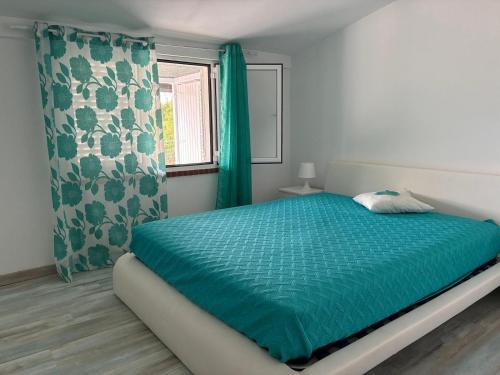 a bedroom with a bed with blue sheets and a window at Coruche Pool & Jacuzzi Residence - Condomínio Privado in Coruche