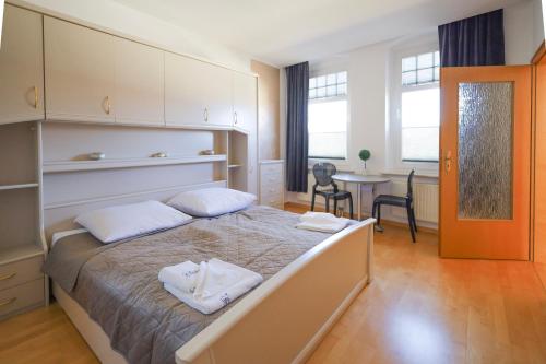 a bedroom with a bed and a table and chairs at Bryza Homes - Villa Linde - Parkplatz - Ahlbeck - Patio in Ahlbeck
