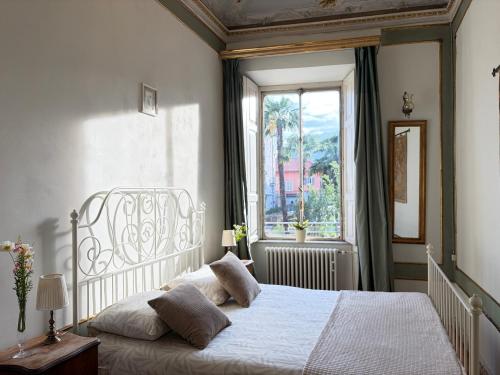 a bedroom with a white bed and a window at Bed & Blessing / Casa Borgo in Locarno