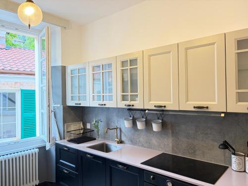 a kitchen with blue cabinets and a sink and a window at Bed & Blessing / Casa Borgo in Locarno