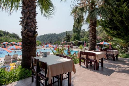 a restaurant with tables and chairs and a swimming pool at Club Pink Palace Hotel in Oludeniz