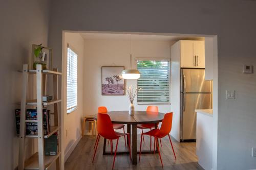 a kitchen with a dining room table and red chairs at Casa MIA central location, free parking, fully equipped in Miami