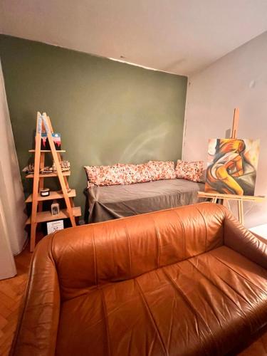 a living room with a leather couch and a bed at Apartment 16 in Probištip