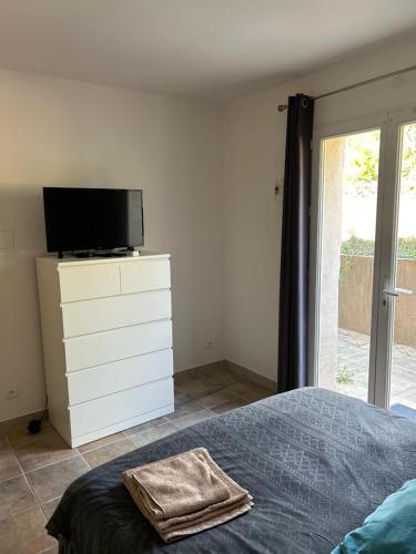 a bedroom with a bed and a tv on a dresser at La Marie Blanche in Saint-Zacharie