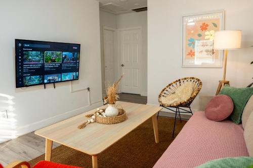 a living room with a table and a tv on a wall at Casa MIA central location, free parking, fully equipped in Miami