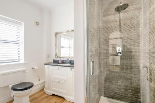 a bathroom with a shower with a toilet and a sink at 3 Bed in Holt oc-2280 in Holt