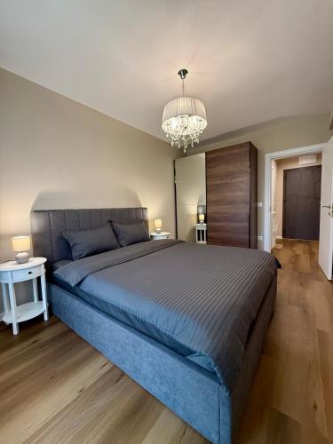 a bedroom with a large blue bed and a chandelier at Luxury Apartment Sofia in Sofia