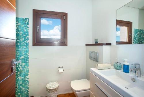 a bathroom with a sink and a toilet and a window at Ses Crestes in Portocolom