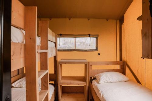 a small room with two bunk beds and a window at Vakantiepark Eigen Wijze in Bant