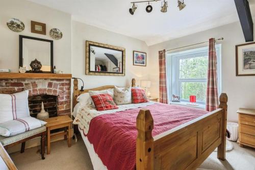 a bedroom with a large bed and a fireplace at Coachman's Cottage B & B in Plymouth