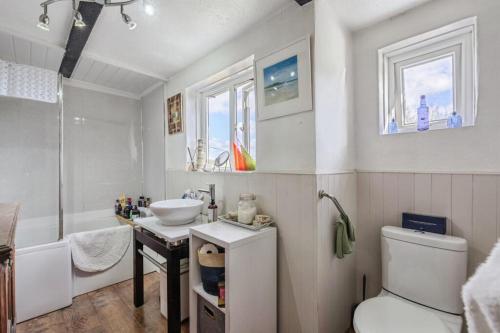 a bathroom with a sink and a toilet and a tub at Coachman's Cottage B & B in Plymouth