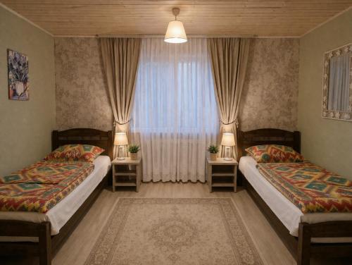 a bedroom with two beds and a window at Pid Skeleyu in Lazeshchyna