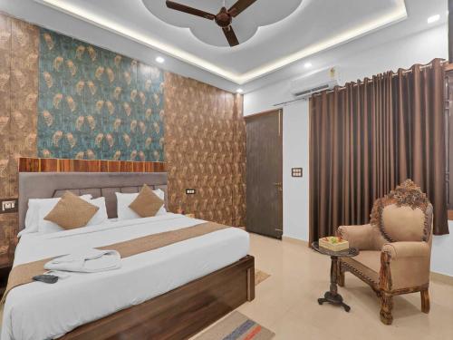 a bedroom with a bed and a chair at Palette Oraya Greens by CheckIn, Kathauta Lake, Lucknow in Chinhat