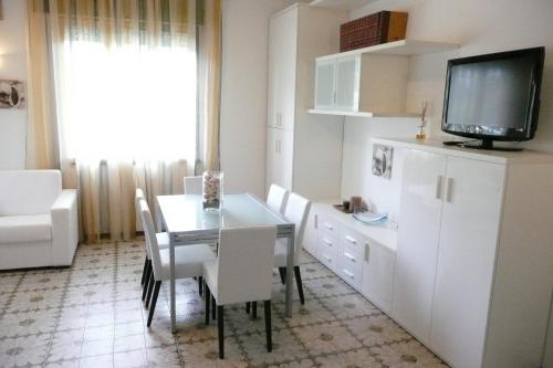 a kitchen with a table and chairs and a television at Hotel Flora in Milano Marittima