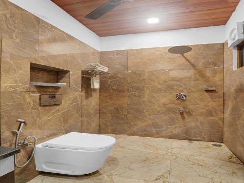 a bathroom with a toilet and a shower at Palette Oraya Greens by CheckIn, Kathauta Lake, Lucknow in Chinhat