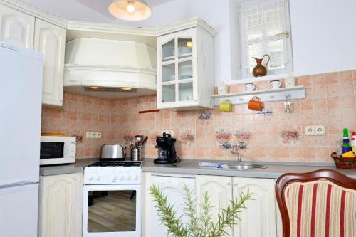 a kitchen with white cabinets and white appliances at Viktória Inn Tihany in Tihany