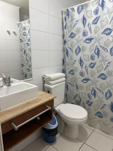 a bathroom with a toilet and a sink and a shower curtain at 703 Departamento 15 minutos de Aeropuerto Maipu in Santiago