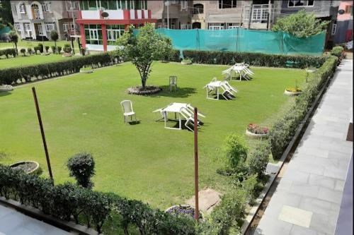 a park with tables and chairs on a green field at Hotel New Sahil - Srinagar in Srinagar