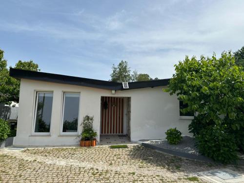 a small white house with a tree at Casa de Ferias Tranquilo in Bitarães