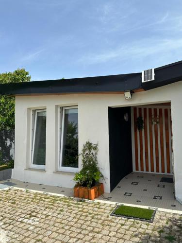a white house with a red and white door at Casa de Ferias Tranquilo in Bitarães