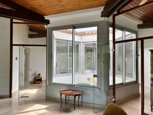 a room withwindows and a table and a chair at L'Olivada, villa d'exception in Ganges