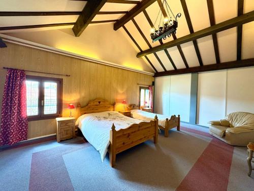 a bedroom with a large bed and a couch at La Fermette du Patural in Ramonchamp