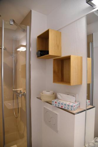 a bathroom with a shower and wooden cabinets at Strandhotel Seehof in Überlingen