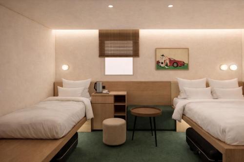 a hotel room with two beds and a table at Hotel Inspiroom Jongro in Seoul