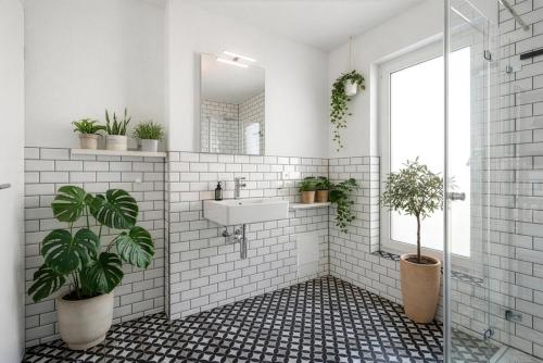 a bathroom with a sink and a mirror and potted plants at Studio 03 - Einzimmerapartment klimatisiert in Friedrichshafen